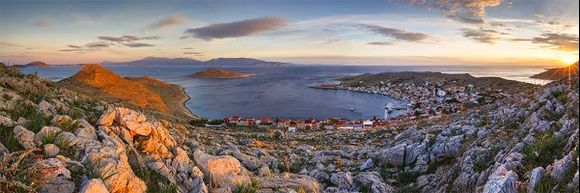 panoramic view of halki village and rhodes island in the distance.