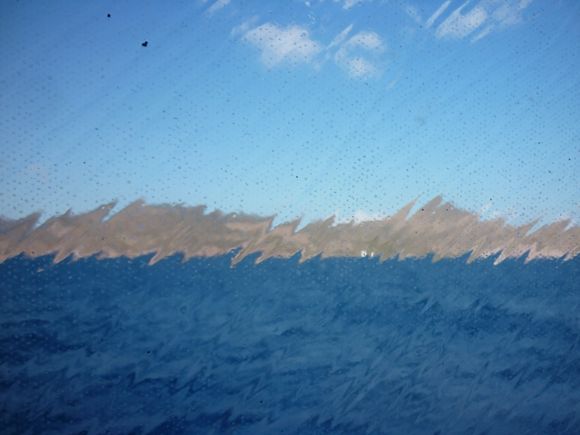View through a sea-splashed window - ferry to Santorini
