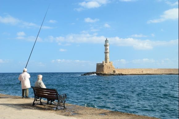 Two fishermen near the venetian lighthouse in Chania. Crete. Greece