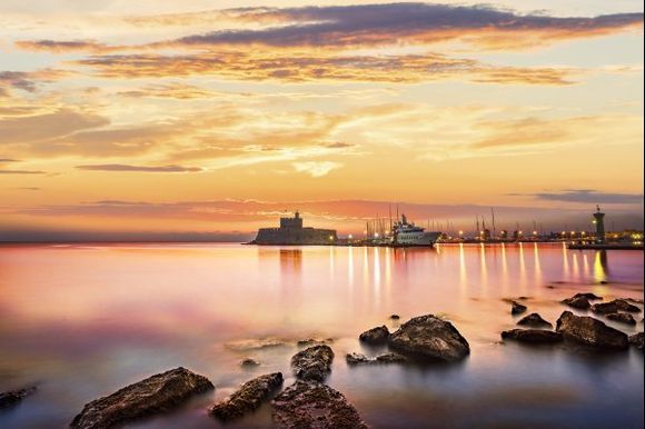 Agios Nikolaos fortress on the Mandraki harbour of Rhodes at sunrise
