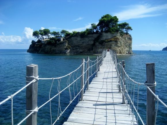 Tiny island connected to Zakynthos via rope bridge.