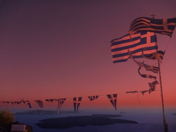 waving flags in the sunset at Imerovigli