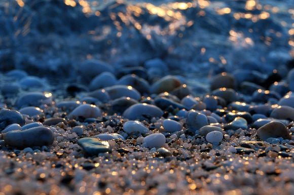 pebbles and waves in the sun light