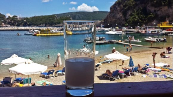 Corfu island, ouzo with ice in the Alipa restaurant in the beach of the small port of Paleokastritsa