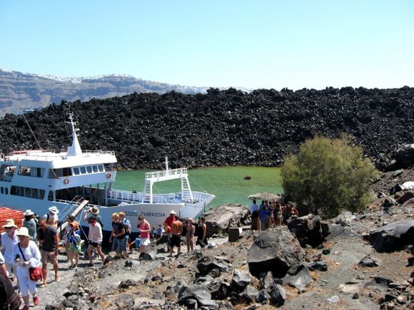 Santorini island, Volcano NEA KAMENI tour, a view of the port of Thirassia. On the background the view of Fira and Imerovigli
