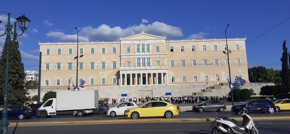 people gathering to see the change of guards in front of the Greek Parliament