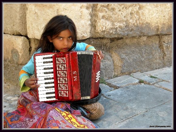 Little girl playing accordion in Old Town.