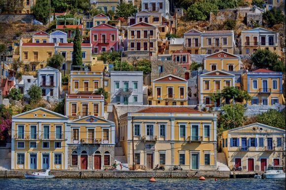 Neo-classical houses climb from the sea. Symi island harbour