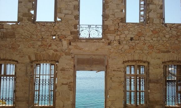 Halki view to the sea through the ruins of a house