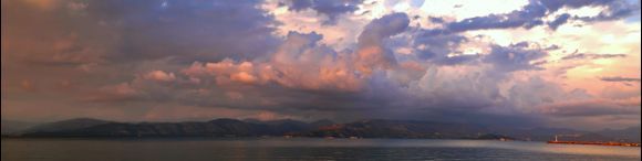 Storm clouds over the mainland in the glow of sunset light, pano of 4 pictures.