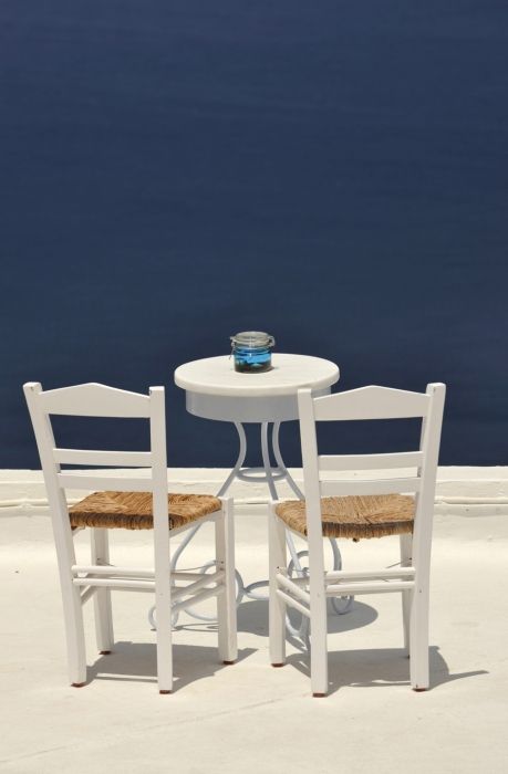 2 chairs and table on the roof of a restaurant at Firostefani Santorini