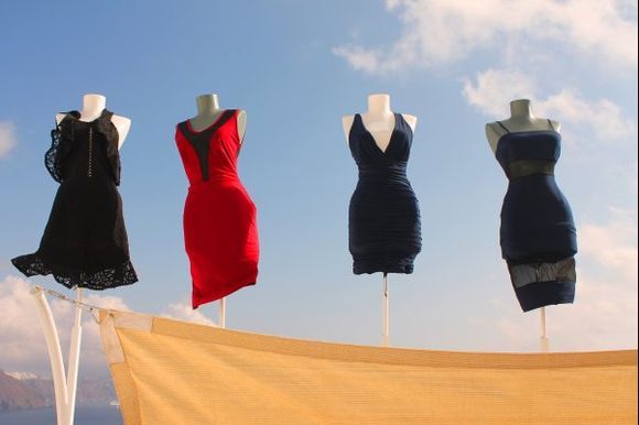 Ladies' dresses flutter in the breeze outside a shop in the village of Oia.