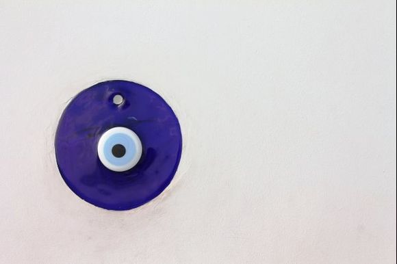 A ceramic eye on a whitewashed wall in Oia.