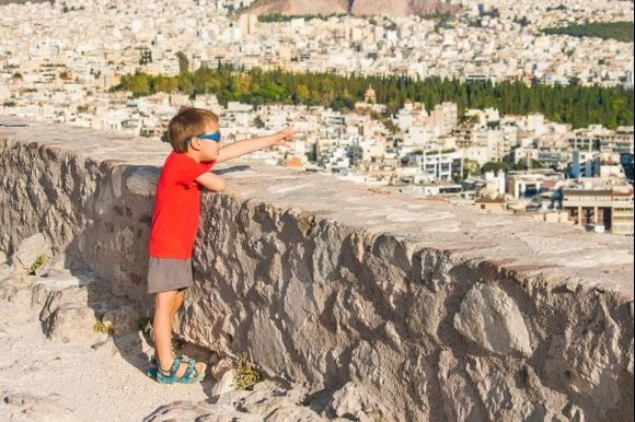 Small child points at Athens  from Acropolis hill.