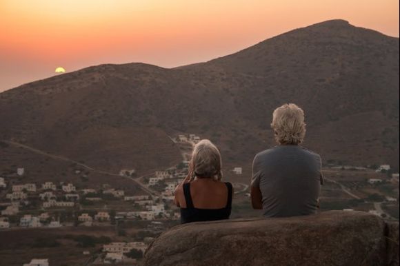 Old couple enjoy the sunset on Ios island.