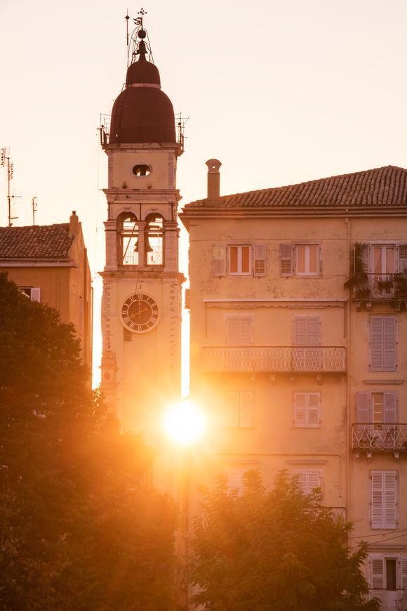 The sunset peeking through Saint Spyridont church clock tower in Corfu town.