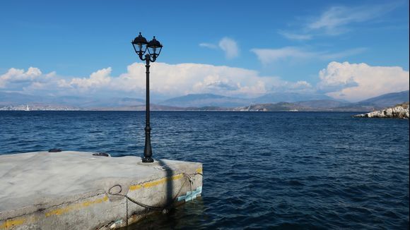 Pier of the harbour of Kassiopi. View out to sea to the Albanian coast.